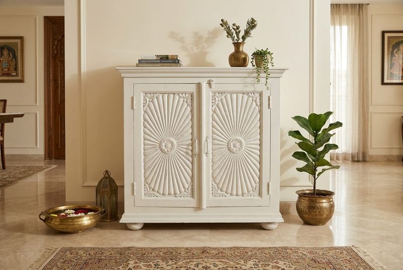 Sunburst carved white cabinet in a styled room